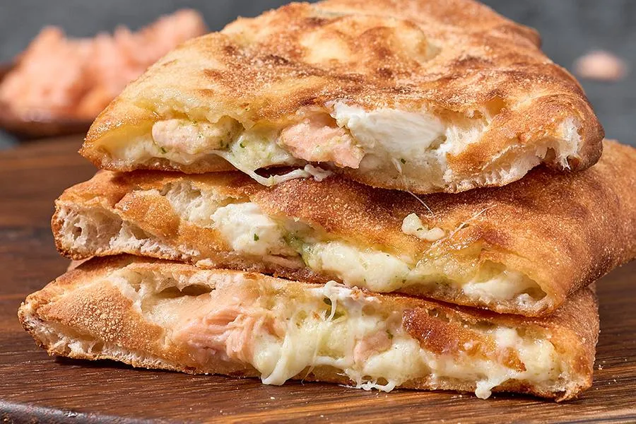 Закрытая пицца кальцоне с лососем и соусом песто